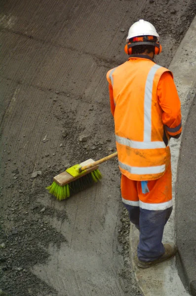 Trabalhador rodoviário vassoura restos de asfalto — Fotografia de Stock