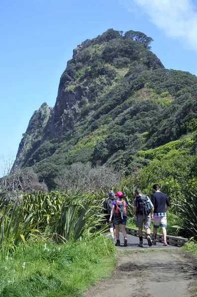 Groep onherkenbaar jonge mensen wandelen in Karekare strand, Nieuw-Zeeland — Stockfoto