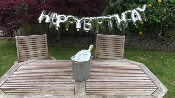 Happy Birthday Party Schild an einem Baum im heimischen Garten aufgehängt — Stockvideo