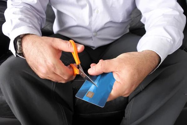 Hombre adulto manos cortando una tarjeta de crédito con un par de tijeras —  Fotos de Stock