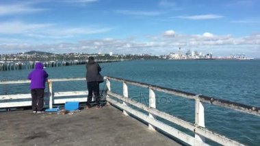 Waitemata Harbour Auckland, Yeni Zelanda üzerinde Okahu bay balıkçılık tanınmaz Asya balıkçılar wharf.