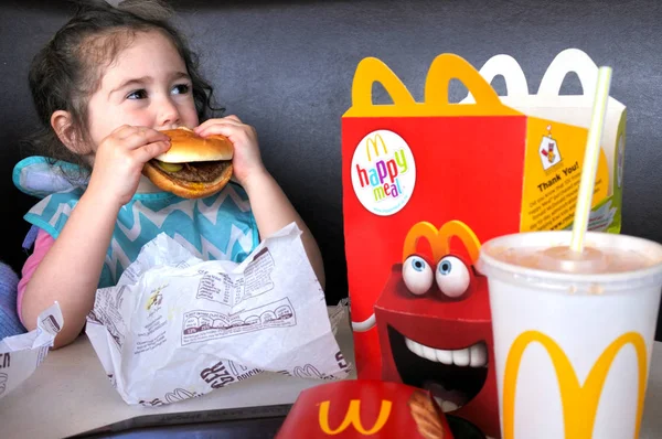 Menina come fast food — Fotografia de Stock