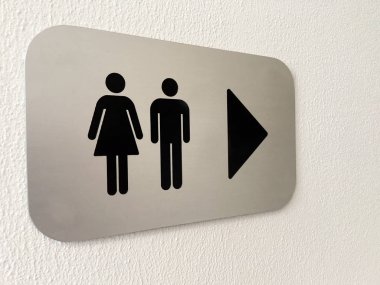 Beyaz bir duvar üzerinde erkek ve kadın tuvalet işareti
