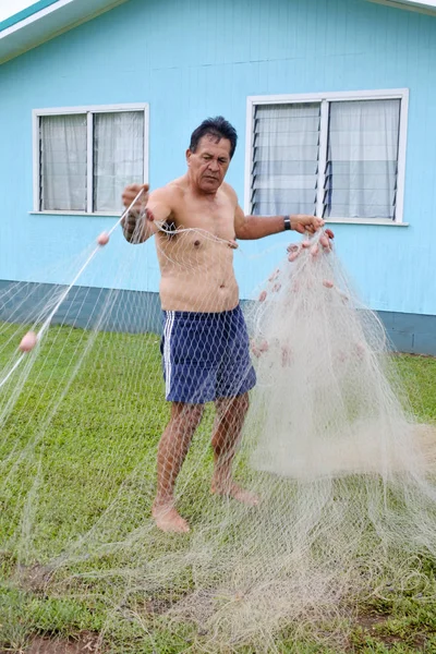 Cook Islander uomo controlla la sua rete da pesca — Foto Stock