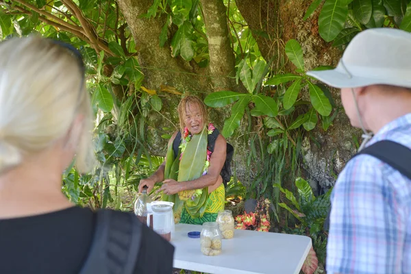 Cook Islander explains about the Noni fruit juice benefits to a — Stock Photo, Image