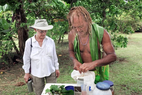 Inselkoch zeigt Touristin, wie man eine Kräuterdri zubereitet — Stockfoto