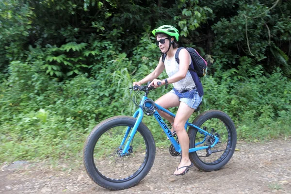 Giovane donna cavalca spingere su mountain bike in Rarotonga Cook Islan — Foto Stock