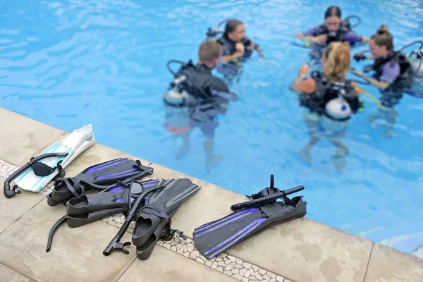 Неузнаваемая группа людей учится нырять с аквалангом в бассейн — стоковое фото