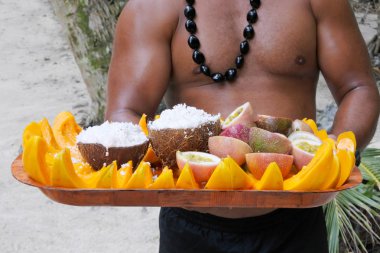 Cook Islander man serves coconut and papaya fruit on a tray in R clipart