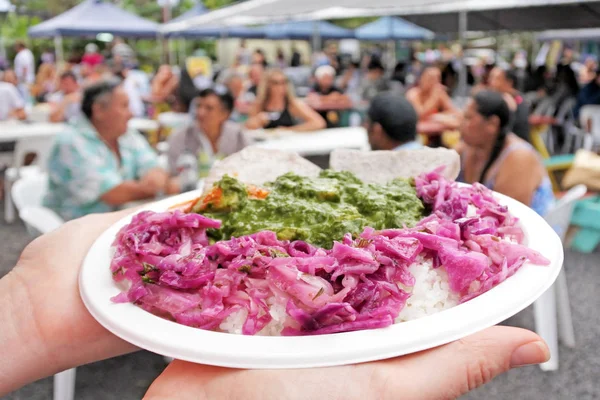 Manos de mujer llevan plato de pollo rukau servido en un plato en Raroto — Foto de Stock