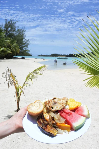 Woman hand carry traditional tropical food in Muri lagoon Raroto — Stock Photo, Image