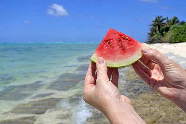 Frau hält eine Scheibe Wassermelone an einem Strand in rarotonga coo hoch — Stockfoto