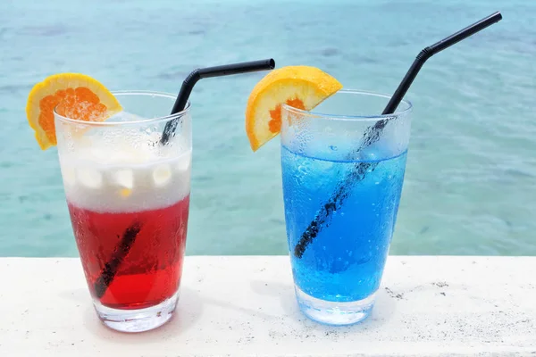 Bebidas de cocktail vermelhas e azuis com gelo servido numa mesa de bilhar — Fotografia de Stock