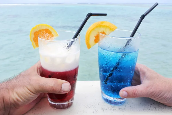 Mężczyzna i kobieta posiada czerwony i niebieski, koktajl napoje z lodem serv — Zdjęcie stockowe