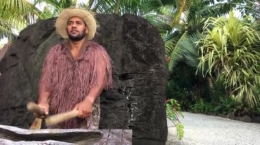 Bir büyük ahşap günlük Pate davul enstrüman Rarotonga, Cook Adaları üzerinde yemek Adalı adam çalış.