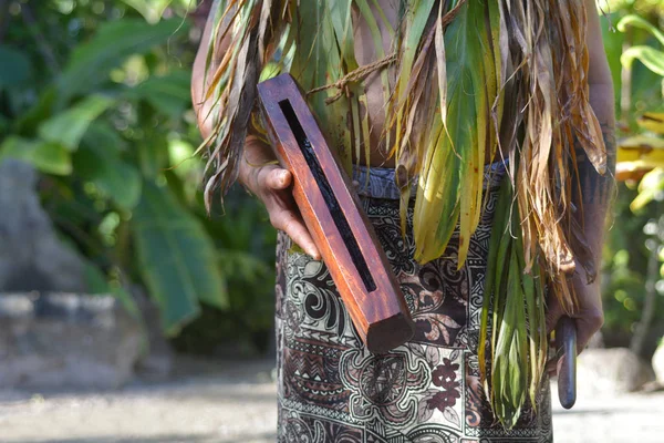 Человек с острова Кук играет на маленьком деревянном инструменте Pate drum instru — стоковое фото