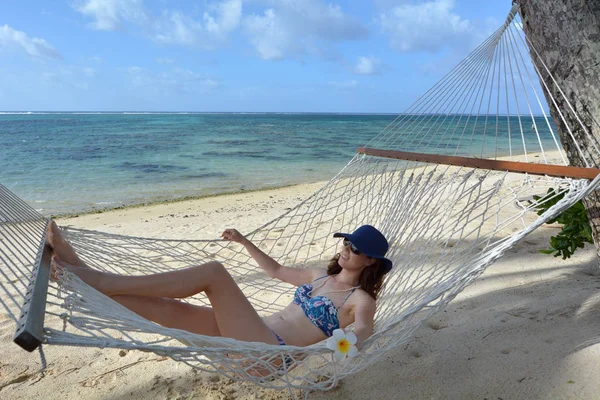 Jonge vrouw ontspannen in een hangmat op een tropische Stille Oceaan eiland b — Stockfoto