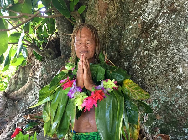 Velho homem ilhéu do Pacífico rezando sob uma árvore de floresta tropical — Fotografia de Stock