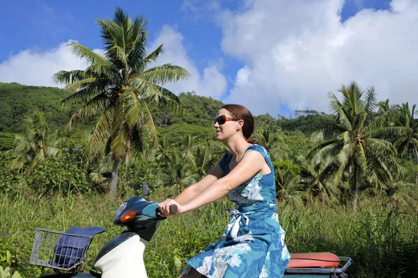 Mujer montando un scooter en una isla tropical pacífica de Ra — Foto de Stock