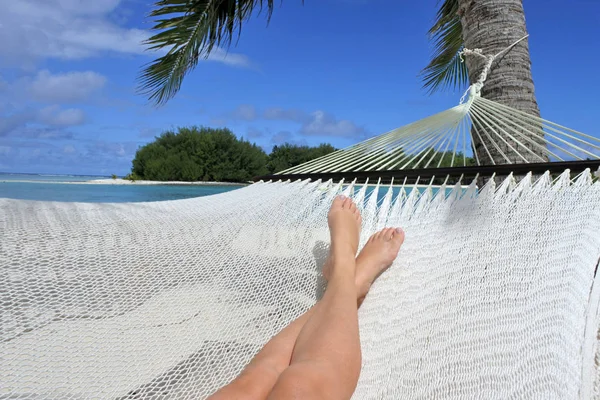 Akční žena ležela na relaxační houpací sítě v laguně Muri v Rarot — Stock fotografie