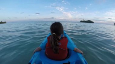 Genç kız oturup bir kayık, Muri lagün üzerinde gece karanlığında Rarotonga içinde kanosu, Cook Adaları. Gerçek insanlar. Kopya alanı