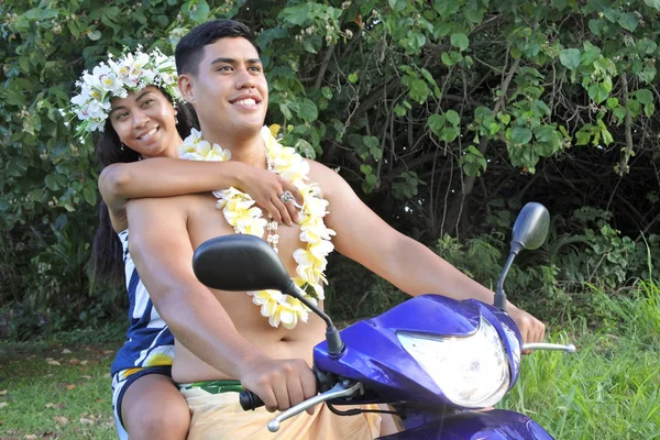 Happy Pacific Islander  honeymoon couple riding motor scooter in