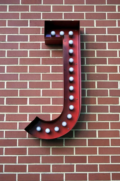 De letter J op een bakstenen muur — Stockfoto