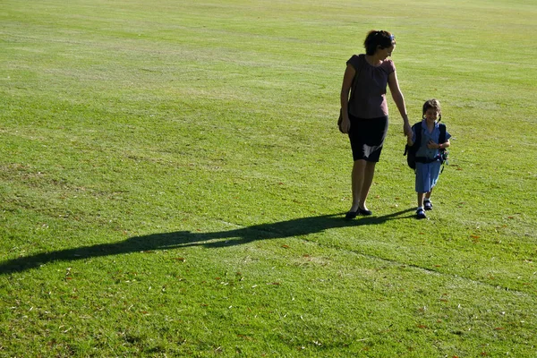 Mother and daughter walking together to school — Stock Photo, Image