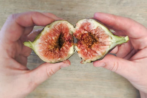 Person hands open a ripe fig — Stock Photo, Image