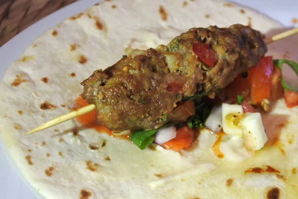 Palillo de kebab a la parrilla en pan plano con ensalada . —  Fotos de Stock