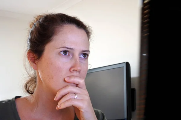 Serious upset adult woman looking a computer screen monitor. Concept photo of upset wife, mother, parent find that husband, child watching porn sites in browsing history. Real people. Copy space.