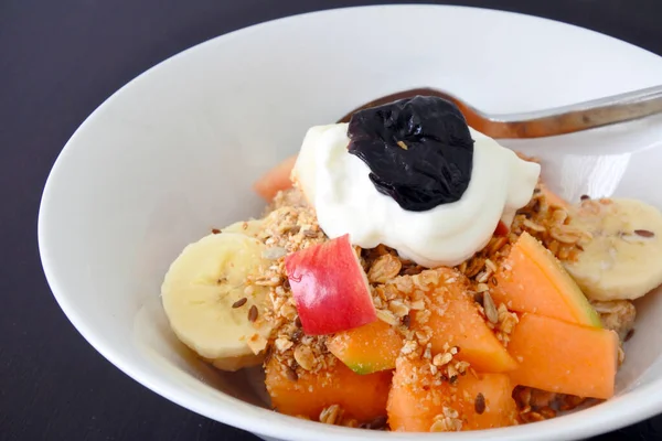 Healthy fresh fruit cereal and Greek yogurt served in a bowl for breakfast. Healthy food and eating background and texture.