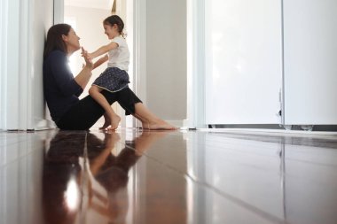 Mutlu anne oyun oynuyor ve küçük kızıyla (6 yaşında) ev koridorunda eğleniyor..