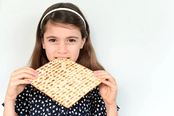 美しいユダヤ人の少女 10歳 過越のユダヤ人の休日にマッツォパンを食べるカメラを見て 本物の人間だ スペースのコピー — ストック写真