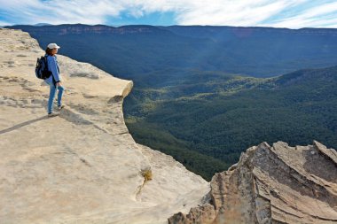 Avustralya 'nın New South Wales kentindeki Blue Mountains Ulusal Parkı' nda gün batımında Lincoln Rock Lookout 'tan manzaraya bakan genç bir kadın. Gerçek insanlar. Boşluğu kopyala