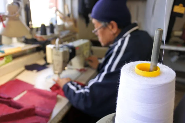 伝統的なテーラーズショップで生地をステッチするためにミシンを使用してプロの仕立屋 70歳 本物の人々 — ストック写真