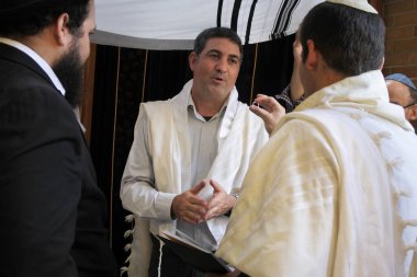 Haham, bir Yahudi 'ye, sinagogdaki bir Ortodoks Yahudi nikah töreninde kendi parasıyla evlilik yüzüğünü alıp almadığını soruyor. Gerçek insanlar. Boşluğu kopyala