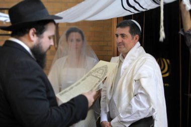 Yahudi Evlilik Sözleşmesi 'ni (Ketubah) Yahudi geline okuyan haham ve modern Ortodoks Yahudi düğününde damat. Gerçek insanlar. Boşluğu kopyala