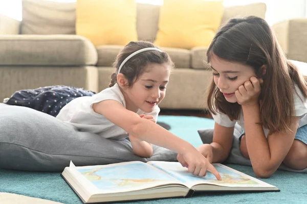 Karantinadaki Mutlu Kız Kardeşler Evde Birlikte Kitap Okuyorlar Gerçek Insanlar — Stok fotoğraf