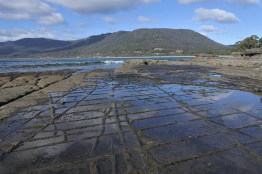 Tasmanya, Avustralya 'daki Tasman Yarımadası' ndaki Pirates Körfezi 'ndeki Tessellated Pavement üzerinde gökyüzü enflasyonu manzarası