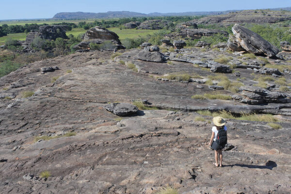 Australian adult woman tourist hiking at Ubirr rock art site in Kakadu National Park Northern Territory of Australia.