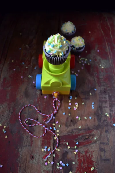 Blue and Yellow chocolate cupcake with spring sprinkles on pull toy