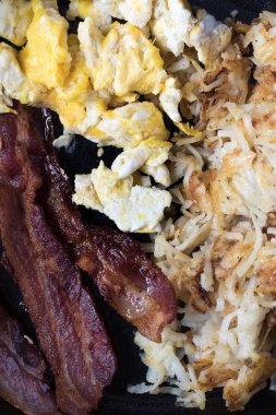 Dökme demir tavada pişmiş yumurta, domuz pastırması ve kızarmış patates tatlı