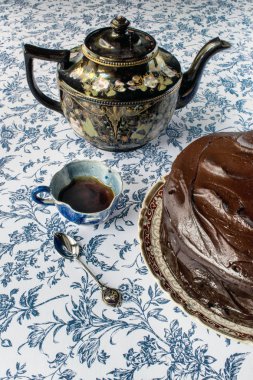 Çikolata kek kahve ve kaşık ile mavi çiçek arka plan üzerine krema