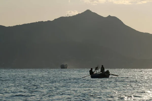 Arka planda, balıkçı ile Ischia Adası tekne kürek