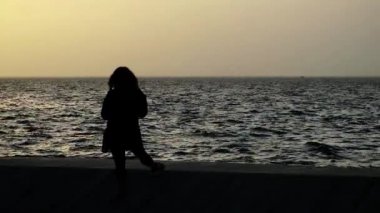 1920 x 1080 25 Fps. çok güzel yalnız kadın ile deniz siluet Video arıyorsunuz bir el Smartphone.