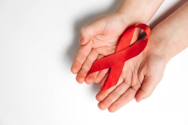 Beyaz arka planda kırmızı kurdele tutan çocukların üst görüntüsü, Hiv farkındalık konsepti, Dünya Yardım Günü. Düz yat, boşluğu kopyala