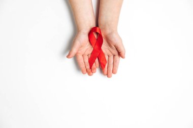 Beyaz arka planda kırmızı kurdele tutan çocukların yatay görüntülerini kapatın, HIV farkındalığı kavramı, Dünya Yardım Günü. Düz konum, üst görünüm, kopyalama alanı