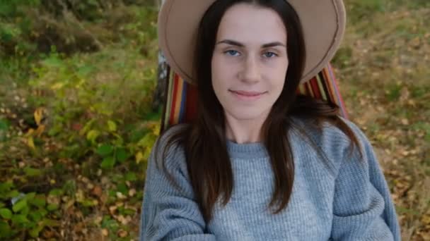 귀여운 여인의 사진은 해먹에 행복하고 독립적 생활을 즐기며 스웨터를 모자를 — 비디오