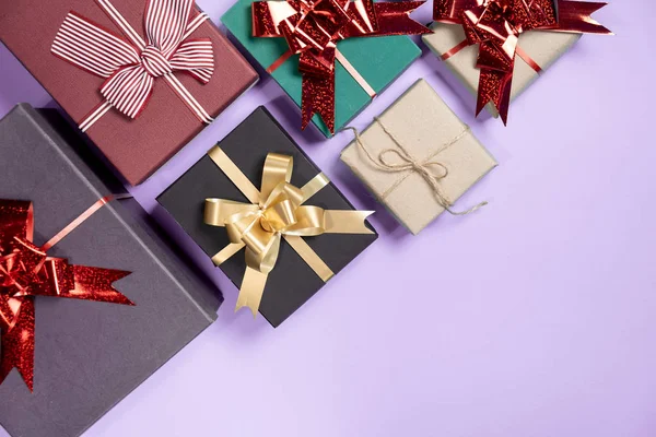 Composition des vacances de Noël. Diverses boîtes-cadeaux sur fond violet pastel. Noël, nouvel an, concept d'anniversaire. Pose plate, vue du dessus, espace de copie — Photo